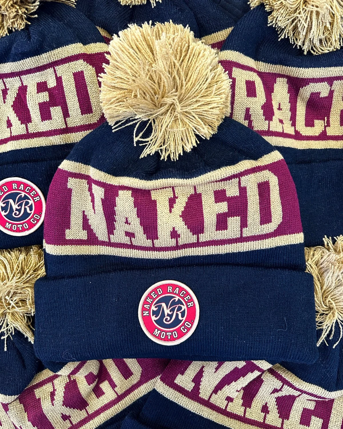 Naked Racer embroidered pom pom beanies, frame-filling composition